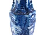 a blue and white vase sitting on a white surface