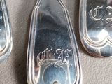 three silver spoons sitting on top of a table next to each other