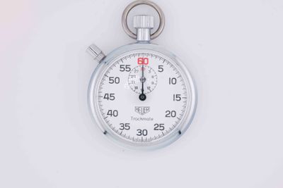 a stopwatch on a white surface with a white background