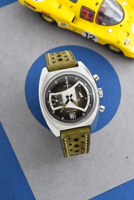 une petite voiture jaune et une montre posées sur une table