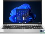 un ordinateur portable avec un écran bleu et un clavier posé sur une surface blanche