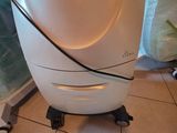a white and black robot sitting on a tiled floor