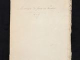 an old book with writing on it sitting on a black surface