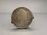 a close up of a coin on a table with a gray background