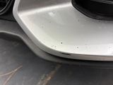 a close up of a car ' s front bumper with dirt on it