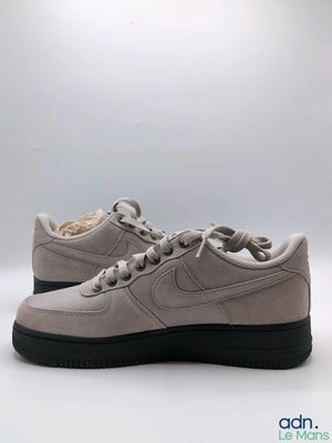 La Nike Air Force 1 Low est une chaussure en daim gris clair dotée d'une semelle noire.