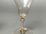 two wine glasses sitting on a table next to each other