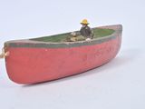 a small red boat with a man sitting in it