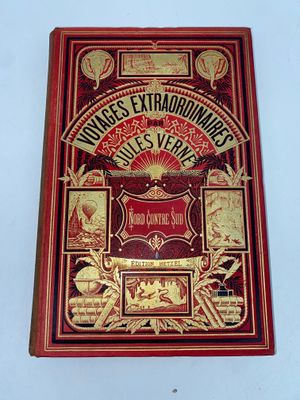 an old book with a red cover and gold lettering on it