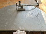 a piece of metal sitting on top of a table next to a piece of wood