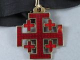 an image of a red and gold cross on a black ribbon