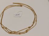 gros plan d'un collier en or sur une surface blanche
