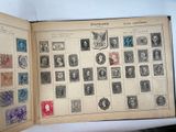 an open book with stamps on it on a table