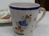 a coffee cup sitting on a table next to a plate