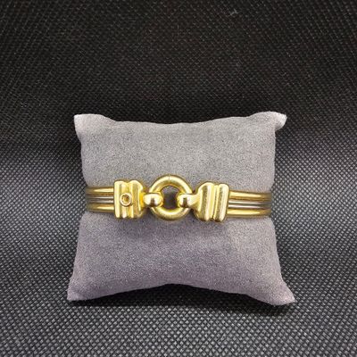 un bracelet en or posé sur un oreiller, lui-même posé sur un autre oreiller