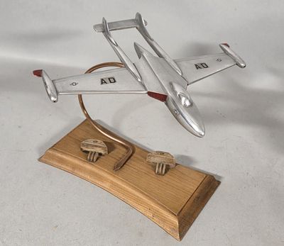 a silver model of a plane on a wooden stand