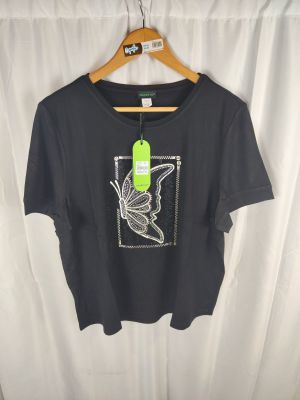 un t-shirt noir orné d'un oiseau, suspendu à un cintre