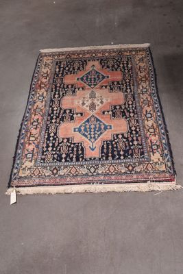 rug on the floor in the middle of a room with a chair in the background