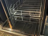 a silver oven with a basket in it on a tiled floor