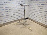 On voit l'image d'un microphone posé sur un trépied devant un mur.