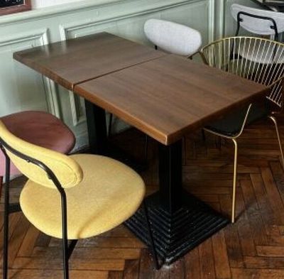 des tables et des chaises dans une pièce avec un parquet et des murs verts