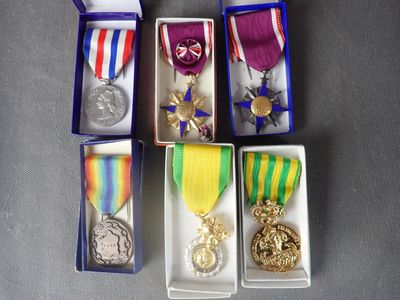 several medals and medals are in small boxes on a table