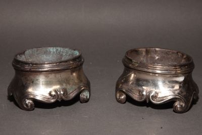 two silver pots sitting next to each other on a table