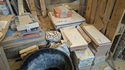 un tas de bois au milieu d'une pièce, avec un seau posé par terre