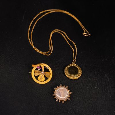 trois colliers en or sur un fond noir, avec une chaîne en or