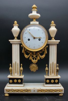 a white and gold clock on a stand on a black background
