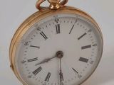 une montre de poche en or avec des chiffres romains sur le cadran
