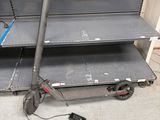 une trottinette posée par terre devant une étagère