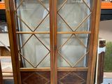 a cabinet that has a glass door on top of it