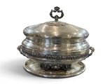 un plat en argent muni d'un couvercle et orné d'un nœud papillon