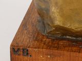 a statue of a dog that is sitting on a wooden block