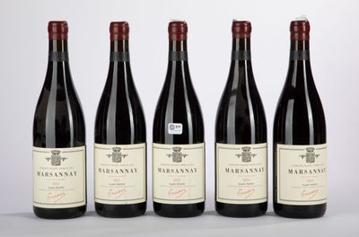 four bottles of red wine are lined up on a table