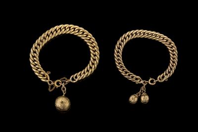 une paire de bracelets en or avec des clochettes