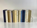 plusieurs livres sont alignés sur une surface blanche