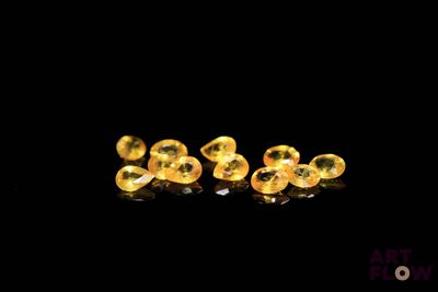 un gros plan sur une paire de boucles d'oreilles jaunes posées sur une surface noire