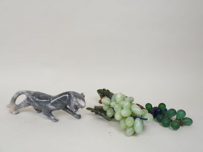 deux figurines représentant un chat et des raisins posées sur une table