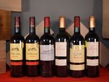 several bottles of wine are lined up on a red table