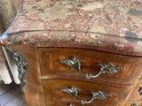 a marble top chest of drawers with a lamp on top