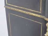 a black and gold cabinet with a clock on top of it