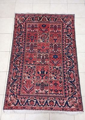 a red and blue rug on a white tiled floor