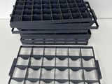 two black plastic trays are stacked on top of each other on a white surface