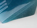 a close up of a blue vase on a white table