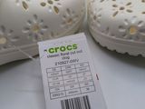 pair of white crocs shoes with price tag on white surface