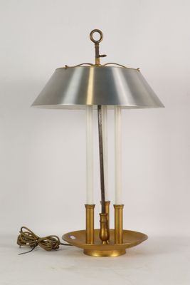 une lampe de table en laiton surmontée d'un abat-jour en verre transparent