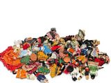 a pile of assorted dolls on a white surface