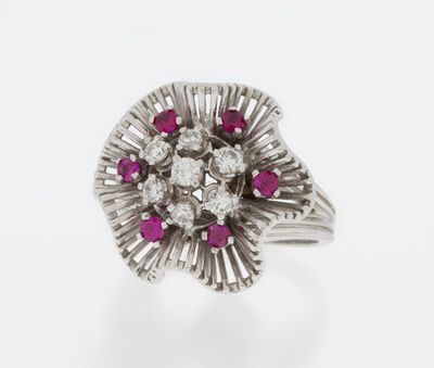 a close up of a diamond and ruby ring on a white background